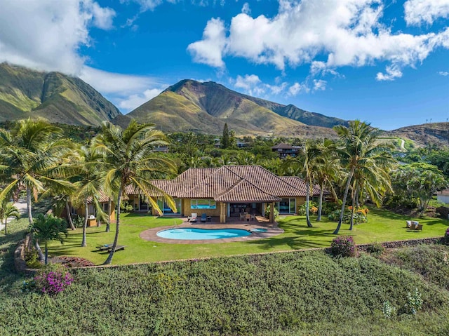 view of swimming pool with a patio, a yard, and a mountain view