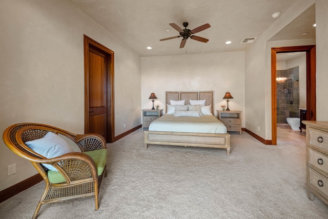 carpeted bedroom with ceiling fan and ensuite bath