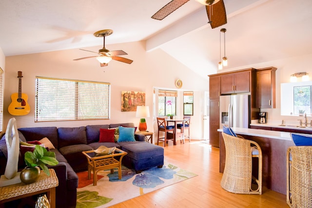 living room with vaulted ceiling with beams, light wood finished floors, and a ceiling fan