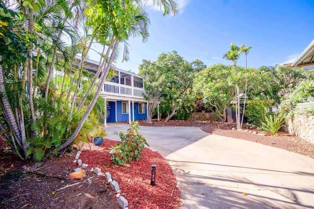 view of front of home with a sunroom, fence, and concrete driveway