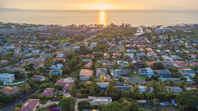 aerial view at dusk with a residential view and a water view