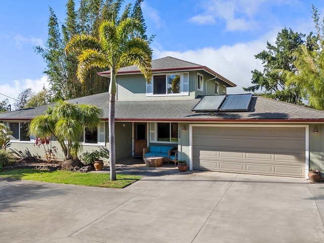 view of front of property featuring solar panels, a porch, a garage, and concrete driveway