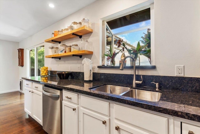 kitchen with a sink, open shelves, white cabinets, dark wood-type flooring, and dark stone counters