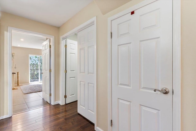corridor with baseboards and dark wood-style flooring