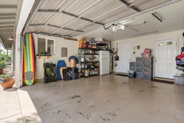 garage with electric panel, a garage door opener, and freestanding refrigerator
