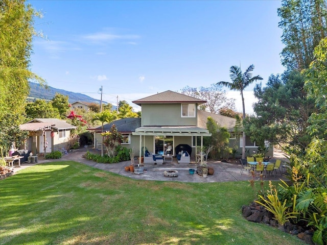 rear view of house with a lawn and a patio area