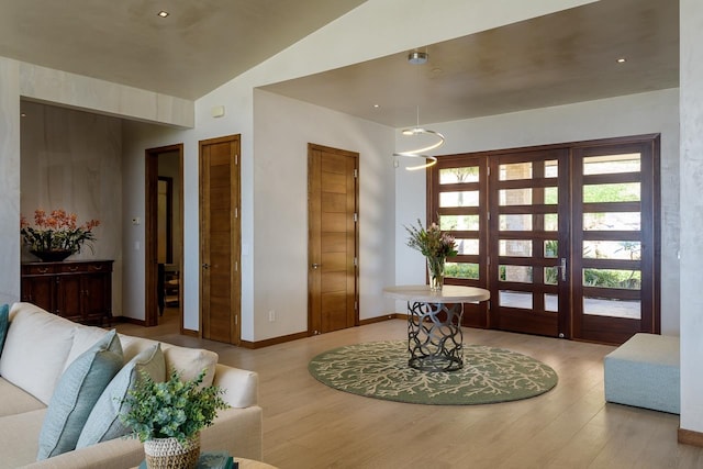 foyer with vaulted ceiling and light hardwood / wood-style flooring