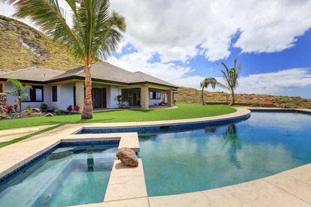 view of pool with a lawn and an in ground hot tub