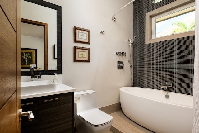 bathroom featuring a bathing tub, vanity, and toilet