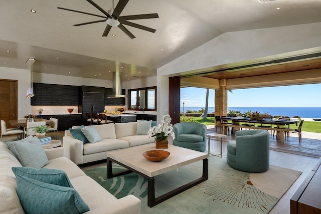 living room featuring high vaulted ceiling, a water view, sink, ceiling fan, and wood-type flooring