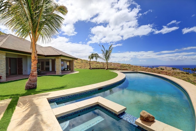 view of pool featuring a lawn, an in ground hot tub, and a patio