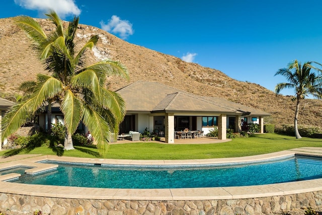 back of property with a lawn and a mountain view