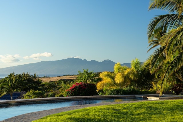 surrounding community with a lawn and a mountain view