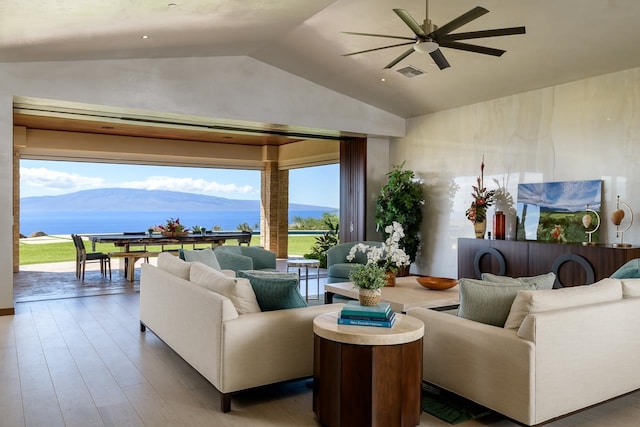 living room featuring a mountain view, ceiling fan, vaulted ceiling, and hardwood / wood-style flooring