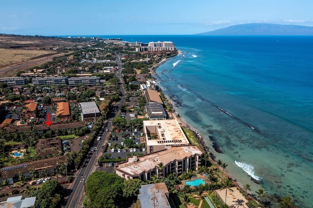 drone / aerial view featuring a water and mountain view and a beach view