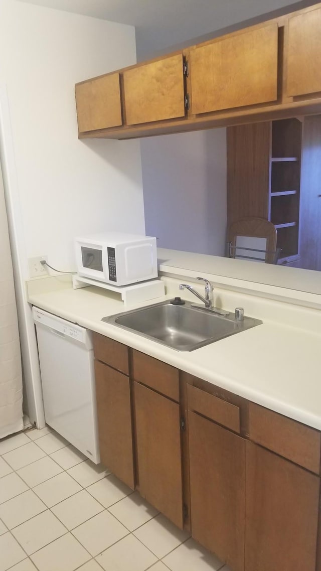 kitchen with sink, light tile patterned floors, and white appliances