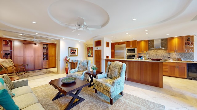 living room with wine cooler, ceiling fan, light tile floors, and a tray ceiling