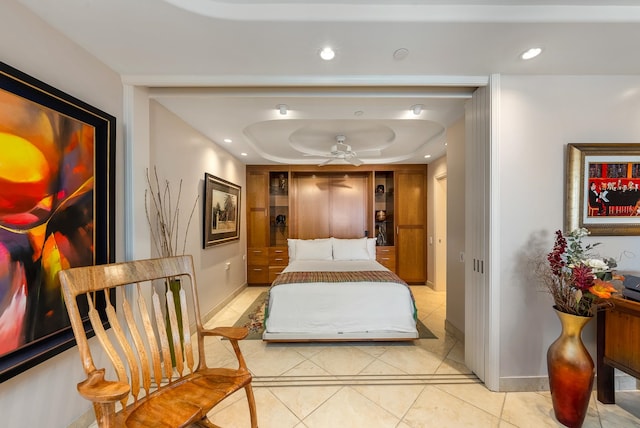 bedroom featuring light tile floors and a tray ceiling