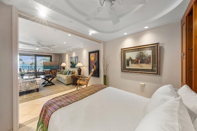 bedroom featuring ceiling fan, a tray ceiling, light tile flooring, and access to exterior