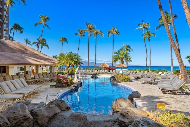 view of swimming pool with a patio and a water view