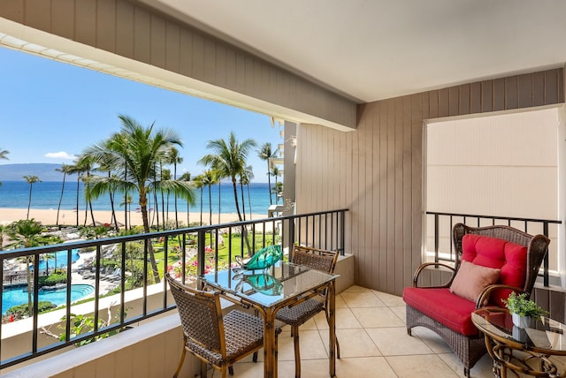 balcony with a water view and a view of the beach