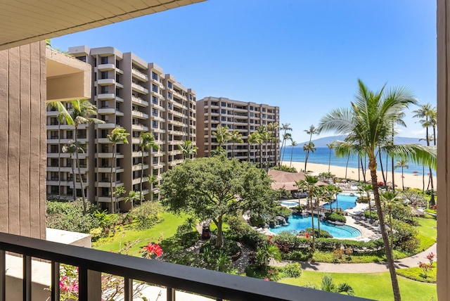 view of building exterior with a water view and a community pool