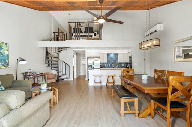 811 S Kihei Rd Unit 2H, Kihei, HI 96753 - dining area featuring a towering ceiling, an AC wall unit, stairs, wooden ceiling, and light wood finished floors