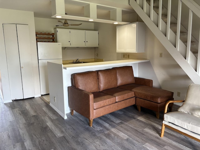1000 Kam V Hwy Unit 320B, Kaunakakai, HI 96748 - living area featuring dark wood finished floors, ceiling fan, and stairway