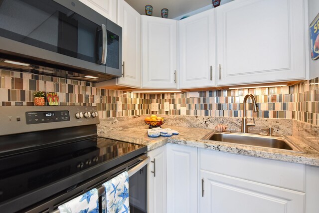 4327 Lower Honoapiilani Rd Unit 207B, Lahaina, HI 96761 - kitchen featuring decorative backsplash, light stone counters, stainless steel appliances, sink, and white cabinets