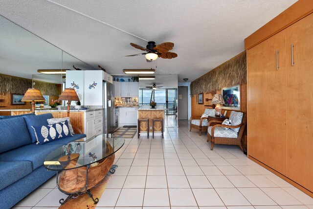 4327 Lower Honoapiilani Rd Unit 207B, Lahaina, HI 96761 - living room with wood walls, light tile patterned floors, and a textured ceiling