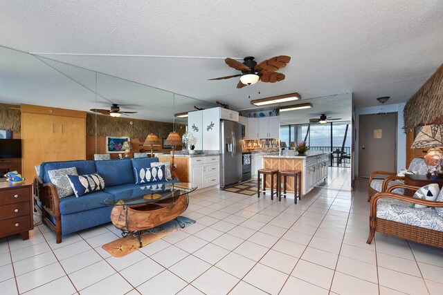 4327 Lower Honoapiilani Rd Unit 207B, Lahaina, HI 96761 - tiled living room featuring a textured ceiling and wooden walls