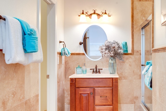 bathroom featuring vanity, a shower with shower door, and tile walls