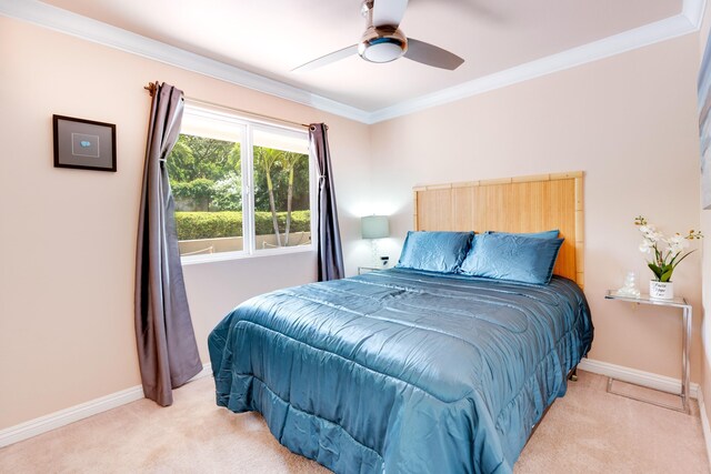 bedroom with crown molding, light colored carpet, and ceiling fan