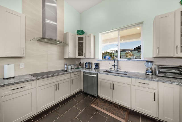 kitchen featuring black electric stovetop, stainless steel dishwasher, sink, wall chimney range hood, and white cabinetry