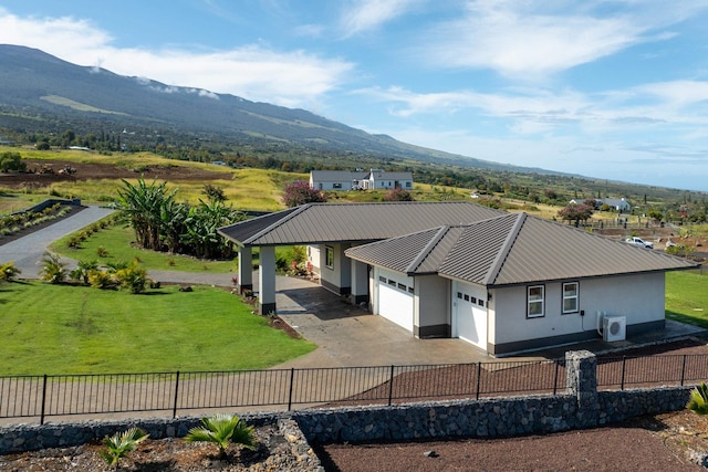 view of front of property with a mountain view, a garage, and a front lawn