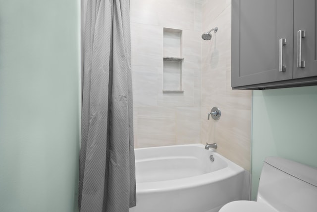 bathroom with shower / bath combination with curtain and toilet