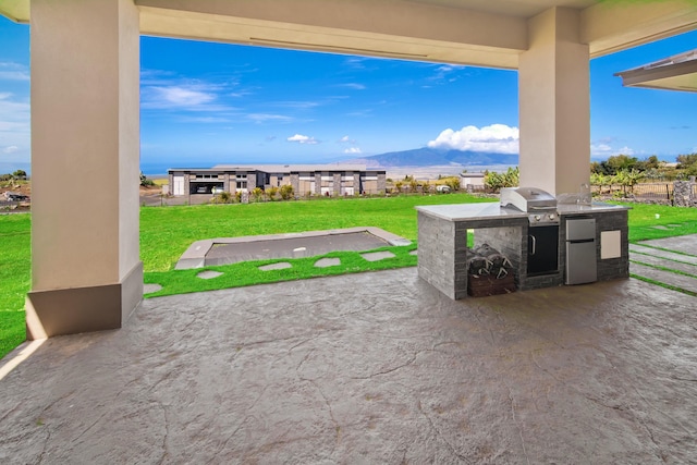 view of patio with a mountain view, a grill, and exterior kitchen