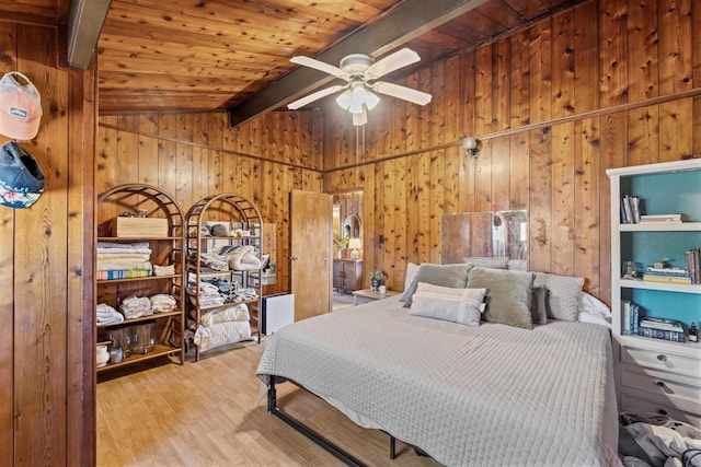 bedroom featuring ceiling fan, wooden ceiling, lofted ceiling with beams, light hardwood / wood-style floors, and wooden walls