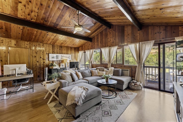 living room with vaulted ceiling with beams, wooden ceiling, a healthy amount of sunlight, and light wood-type flooring