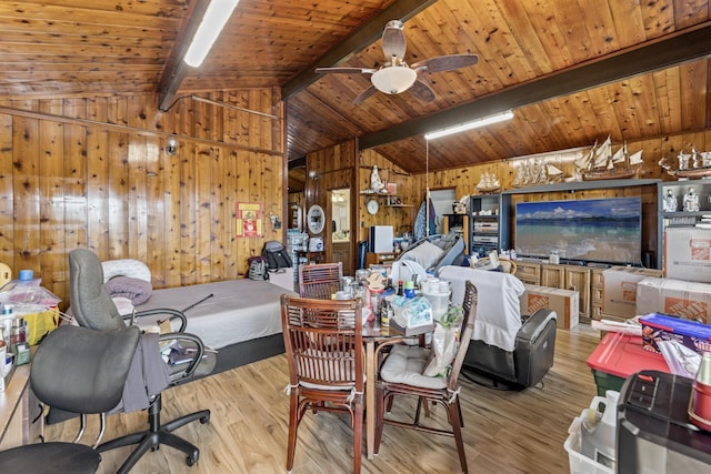 dining room with wood walls, ceiling fan, lofted ceiling with beams, and light hardwood / wood-style floors