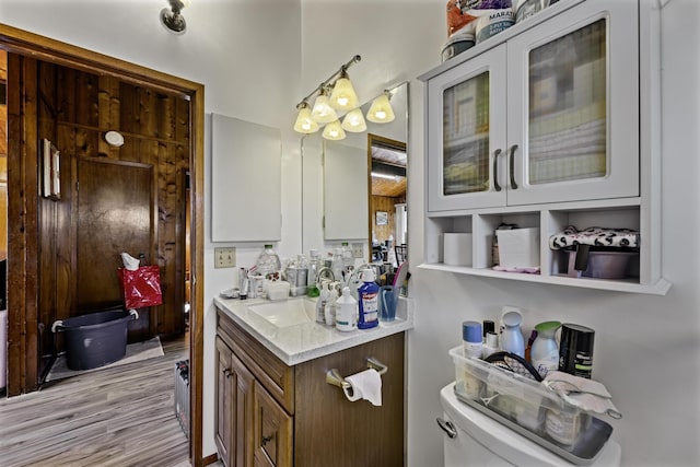 bathroom with hardwood / wood-style flooring, vanity, and toilet