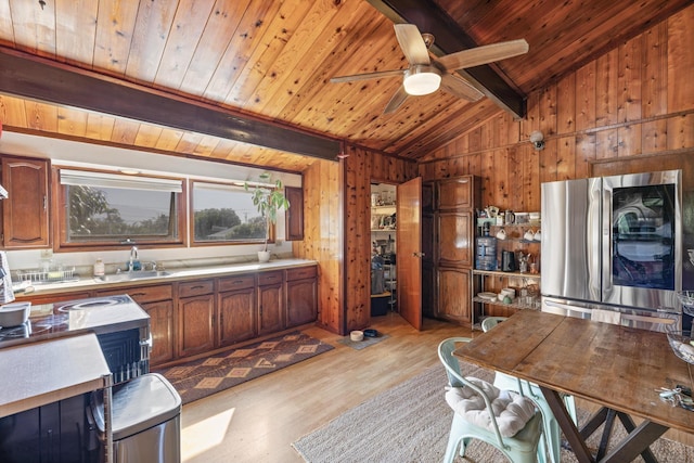 kitchen with ceiling fan, light hardwood / wood-style flooring, stainless steel fridge, wooden walls, and wood ceiling