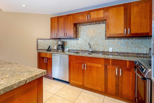 kitchen with light tile patterned floors, stainless steel appliances, backsplash, light stone countertops, and sink