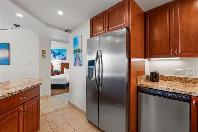 3445 Lower Honoapiilani Rd Unit 204, Lahaina, HI 96761 - kitchen featuring appliances with stainless steel finishes, light tile patterned floors, recessed lighting, brown cabinets, and light stone countertops