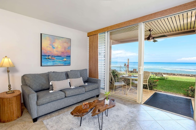 living room featuring expansive windows, tile floors, ceiling fan, and a water view