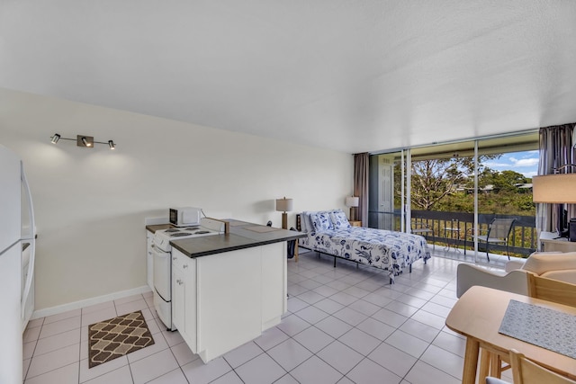 120 Hui Rd F E16, Lahaina, HI 96761 - bedroom with access to exterior, freestanding refrigerator, light tile patterned flooring, and baseboards
