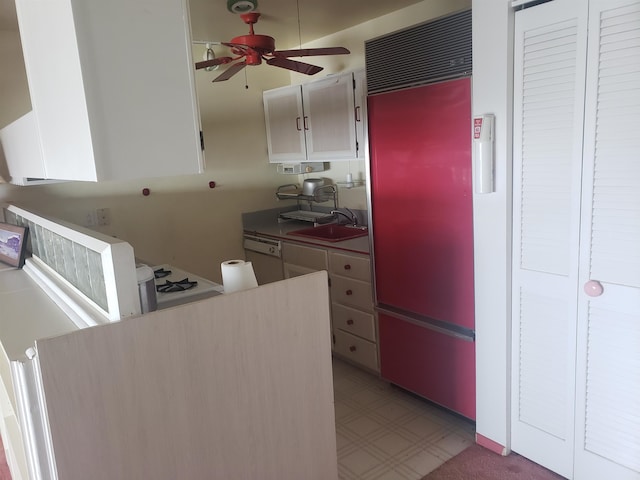 kitchen with sink, ceiling fan, light tile floors, white cabinets, and paneled fridge