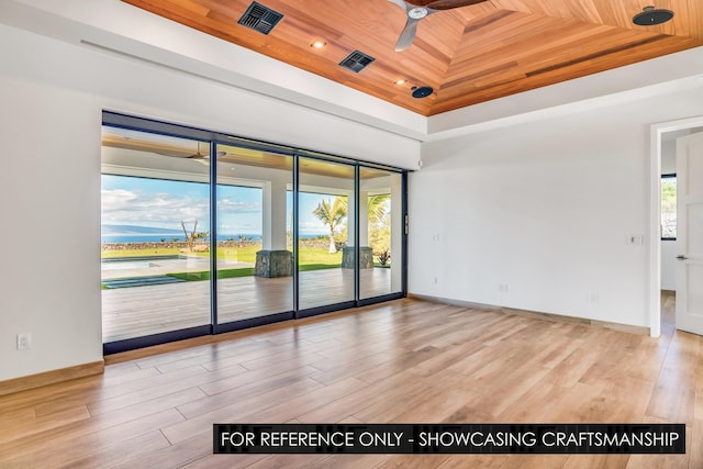 spare room featuring a tray ceiling, wooden ceiling, a ceiling fan, wood finished floors, and baseboards