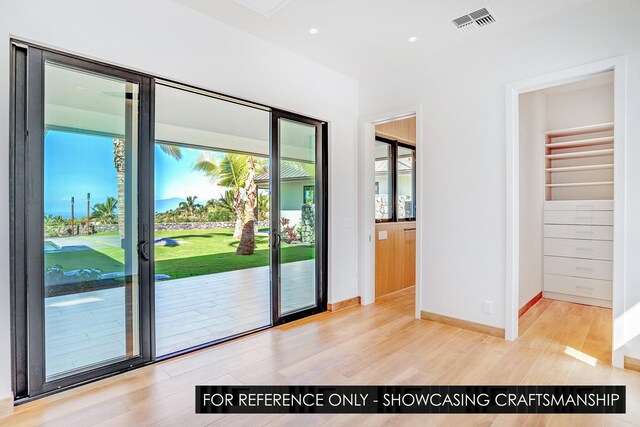 doorway with baseboards, light wood-style flooring, and recessed lighting