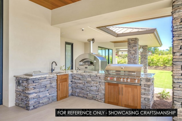 view of patio / terrace with an outdoor kitchen, grilling area, and a sink